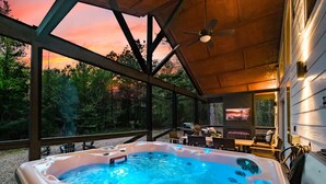 Un bain à remous avec vue sur le coucher de soleil, un ventilateur de plafond et des sièges d’extérieur.