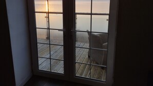 Ein Zimmer mit Blick auf den Sonnenuntergang über dem Wasser.