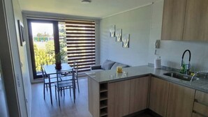 Une cuisine moderne avec un coin repas, des meubles en bois et une vue par la fenêtre.