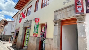 Un edificio con un letrero que dice 'Pucara's Hostel' y un letrero que indica 'TOCAR TIMBRE'.