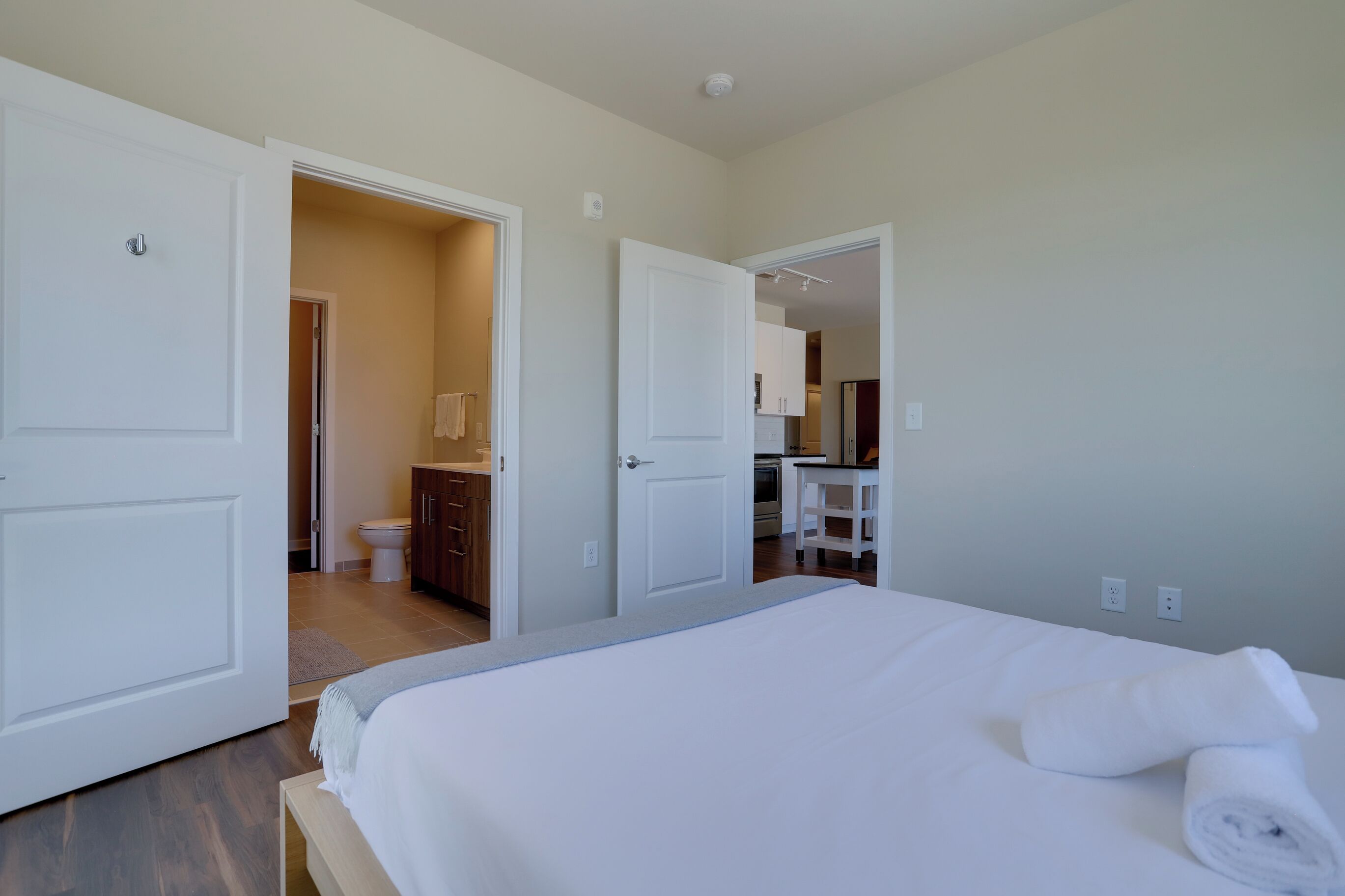 A hotel room with a bed, a bathroom, and a kitchenette.