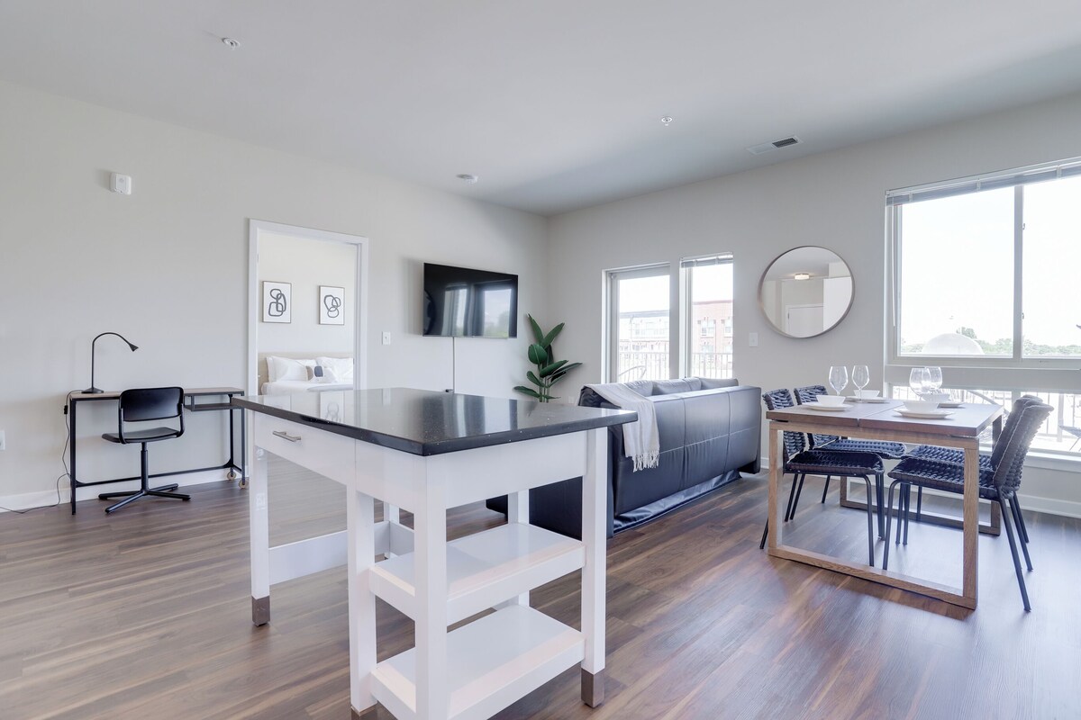 A modern living space with a kitchen, dining area, and seating area.