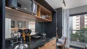 Une cuisine moderne avec un plan de travail noir, un évier en acier inoxydable et des armoires en bois.