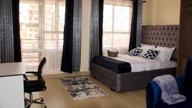 Un dormitorio con cama, escritorio y silla.