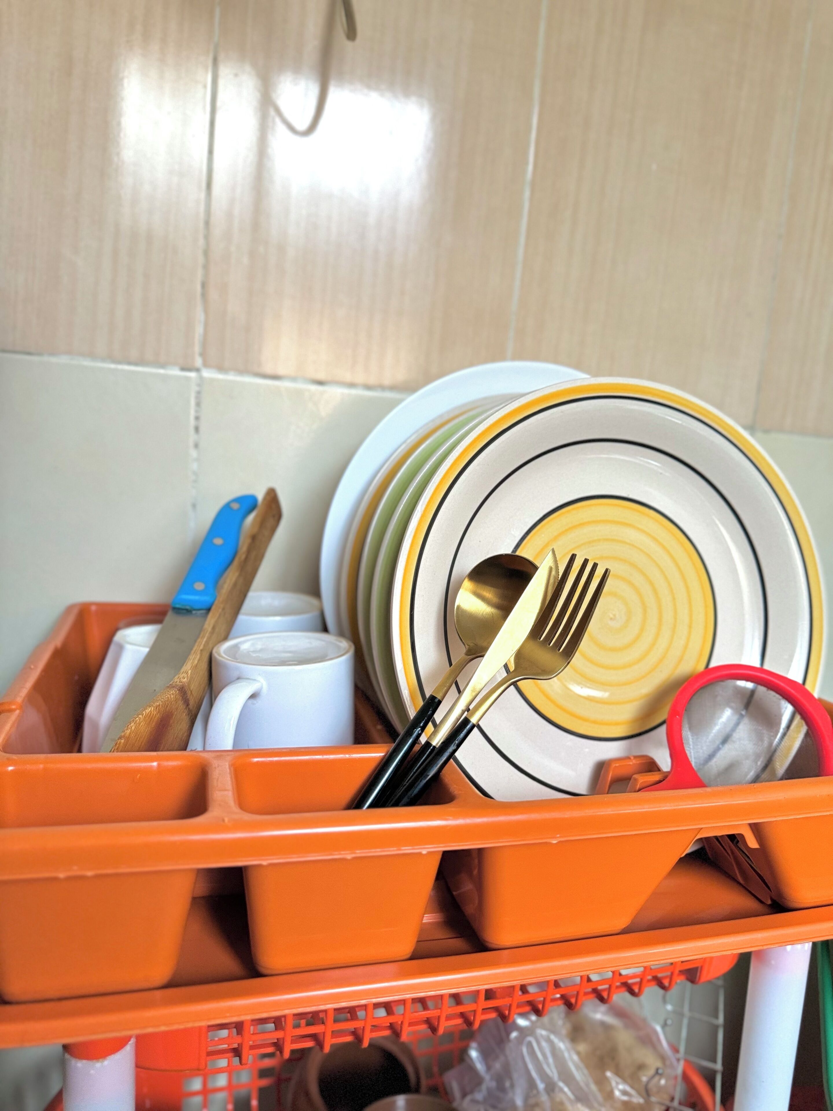 A kitchen utensil organizer with plates, a knife, a spoon, and a fork.