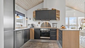 Een moderne keuken met een centraal eiland, inbouwapparatuur en uitzicht op het buitenleven.