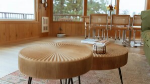 A cozy room with wooden furniture, a round table, and a chair. - Secluded, Bayfront Escape, Luxury Hot Tub, EV Charger, King Beds, Pets OK (Tillamook)