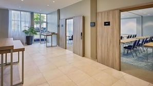 A modern hotel lobby with a long reception desk, a seating area with tables and chairs, and large windows providing natural light. - Courtyard by Marriott Dortmund (Dortmund)