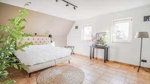 A bedroom with a bed, a round woven rug, a bedside table with a vase, and a lamp. - 4 bedroom lovely home in Havelte (Havelte)