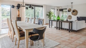 A modern dining area with a large table and chairs, a kitchen area with a dining table, and a living area with a sofa and TV. - 4 bedroom lovely home in Havelte (Havelte)
