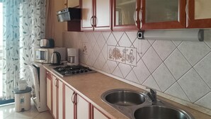 Eine Küche mit einem Gasherd, zwei Spülen, einer Mikrowelle und einer Kaffeemaschine.