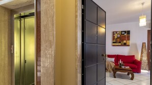 Eine Hotelhalle mit einem roten Sofa, einem Couchtisch und einem Gemälde an der Wand.