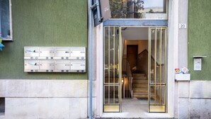 Entrada de un edificio con buzones y una escalera que da acceso al interior.