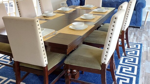 A dining room with a long table set for six, surrounded by six chairs. - Magnificent Villa To Unwind in a great location to Quantico (Fredericksburg)