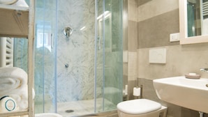 A modern bathroom with a glass-enclosed shower, a white sink, and a toilet. - Apartments Florence - Casa Amici (Firenze)