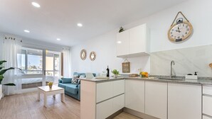 A modern apartment with a kitchen, living area, and a balcony with a view. - MalagaSuite Cozy Studio & Pool Torremolinos (Torremolinos)