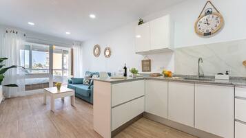 Un apartamento moderno con cocina, sala de estar y un balcón con vistas.
