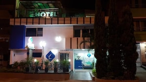 A hotel with a prominent 'HOTEL' sign, a reception area with a blue and white color scheme, and a visible entrance. - Almaviva Casa Hotel (Medellín)