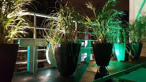 A balcony with potted plants and a railing. - Almaviva Casa Hotel (Medellín)