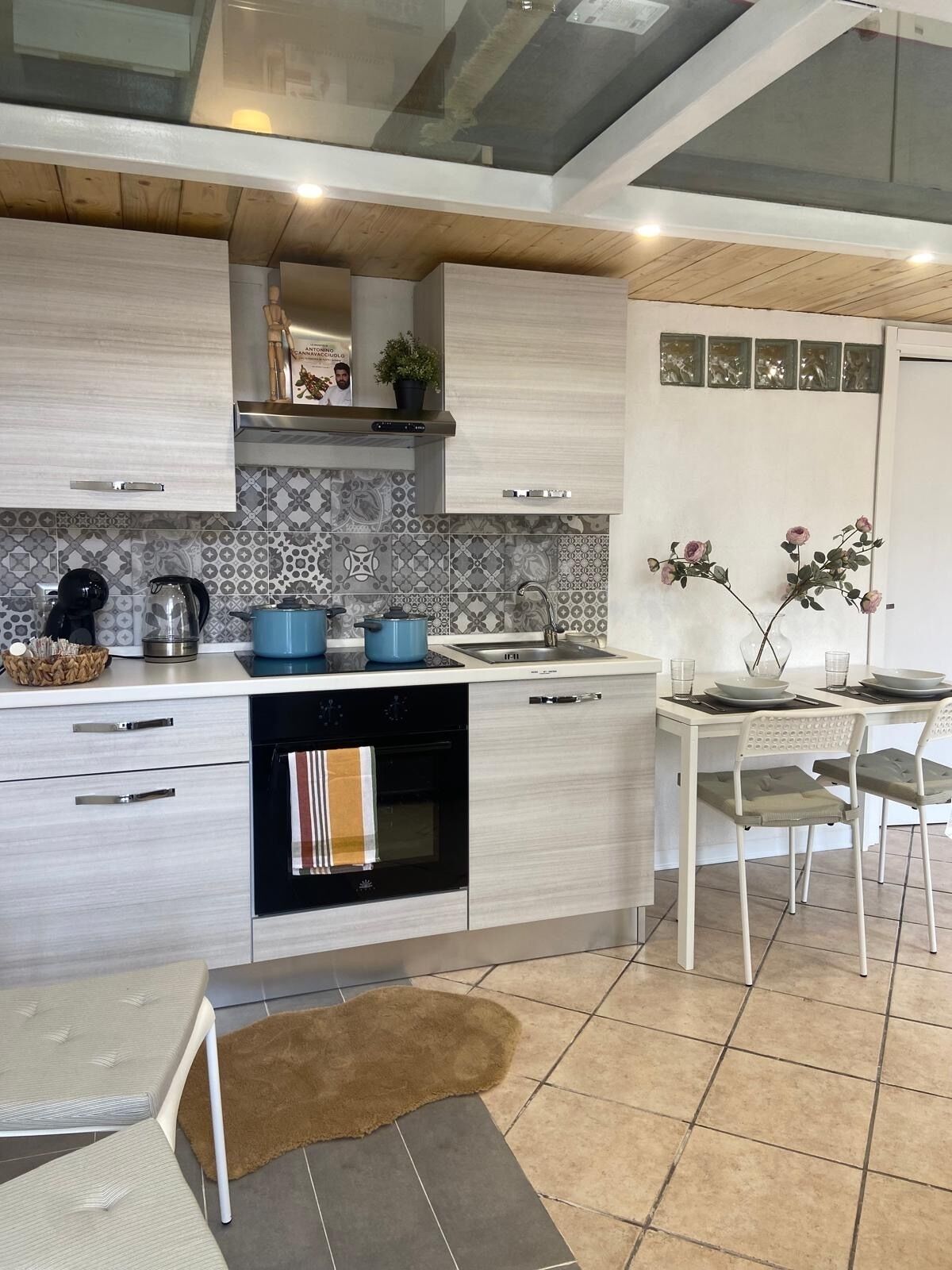 Una cocina moderna con horno empotrado, cafetera y lavaplatos.