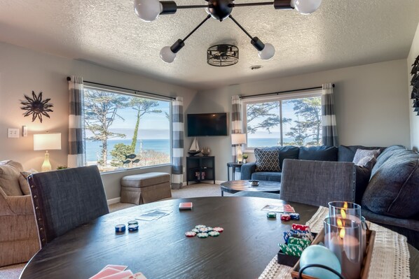 A cozy living room with a round table, sofas, and a TV.