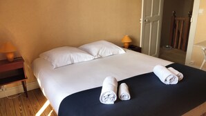 Une chambre d’hôtel avec un grand lit, deux lampes de chevet et un plancher en bois.