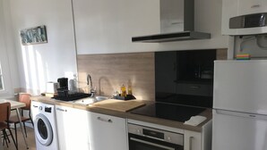 Une cuisine compacte équipée d’un lave-linge, d’un four à micro-ondes, d’une cuisinière et d’un réfrigérateur.