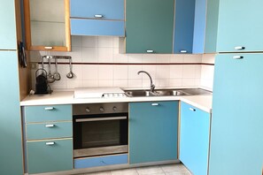 Een koelkast, een oven, eettafels