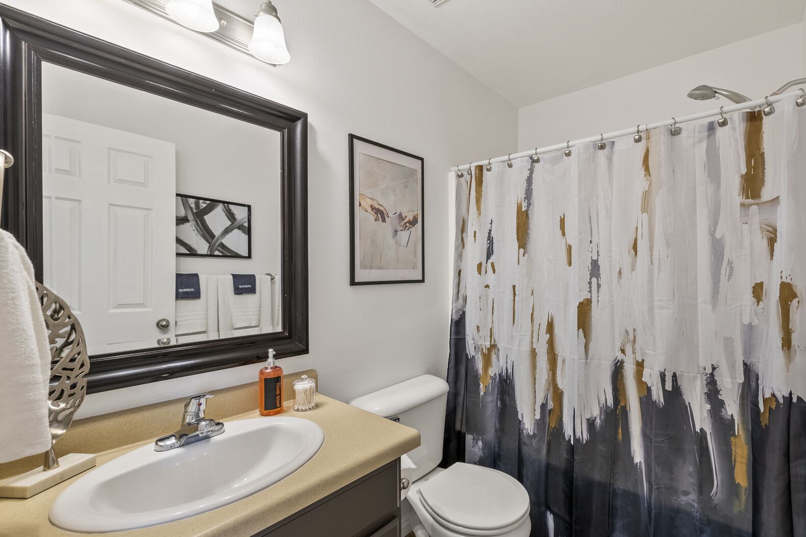 Un baño con lavamanos, inodoro y cortina de ducha.