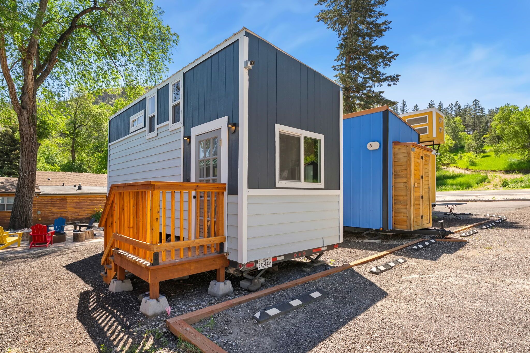 A small, single-story cabin with a wooden deck and a small porch.