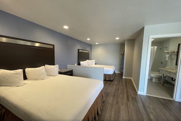 A hotel room with two beds, a small desk, and a bathroom visible through an open door. - Motel6 Yuba City, CA (Yuba City)