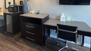 A room with a desk, chair, mirror, and a flat-screen TV mounted on the wall. - Motel6 Yuba City, CA (Yuba City)