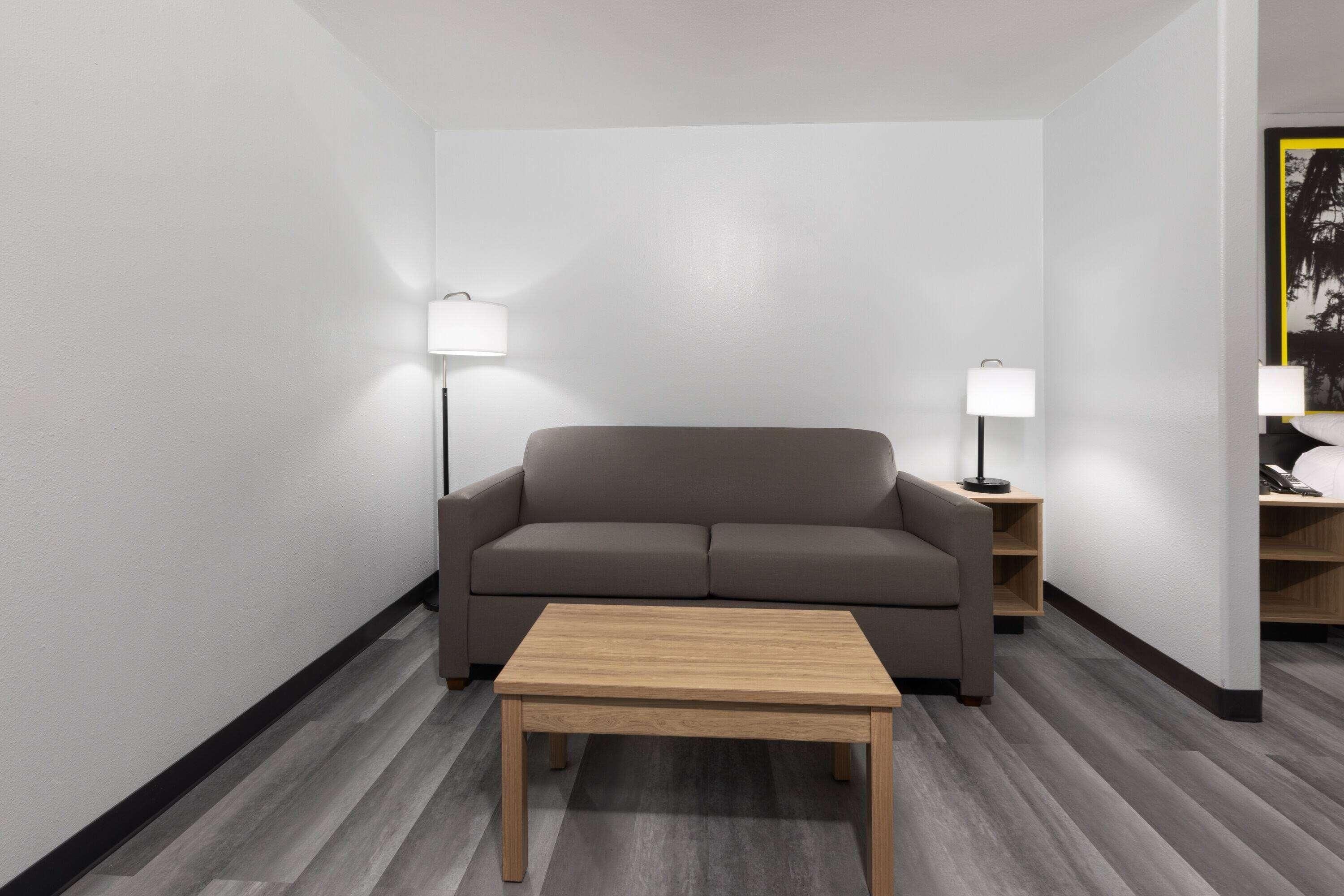 A modern living room with a sofa, a coffee table, and two bedside lamps.