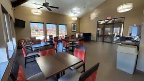 A restaurant with booths and tables, ceiling fans, and large windows. - Super 8 by Wyndham Alexandria LA (Alexandria)