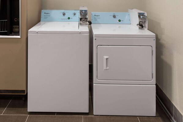 Two stacked Whirlpool front-loading washing machines in a corner. - Super 8 by Wyndham Alexandria LA (Alexandria)