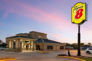 A hotel with a prominent 'Super 8' sign, a covered entrance, and a parking lot. - Super 8 by Wyndham Alexandria LA (Alexandria)