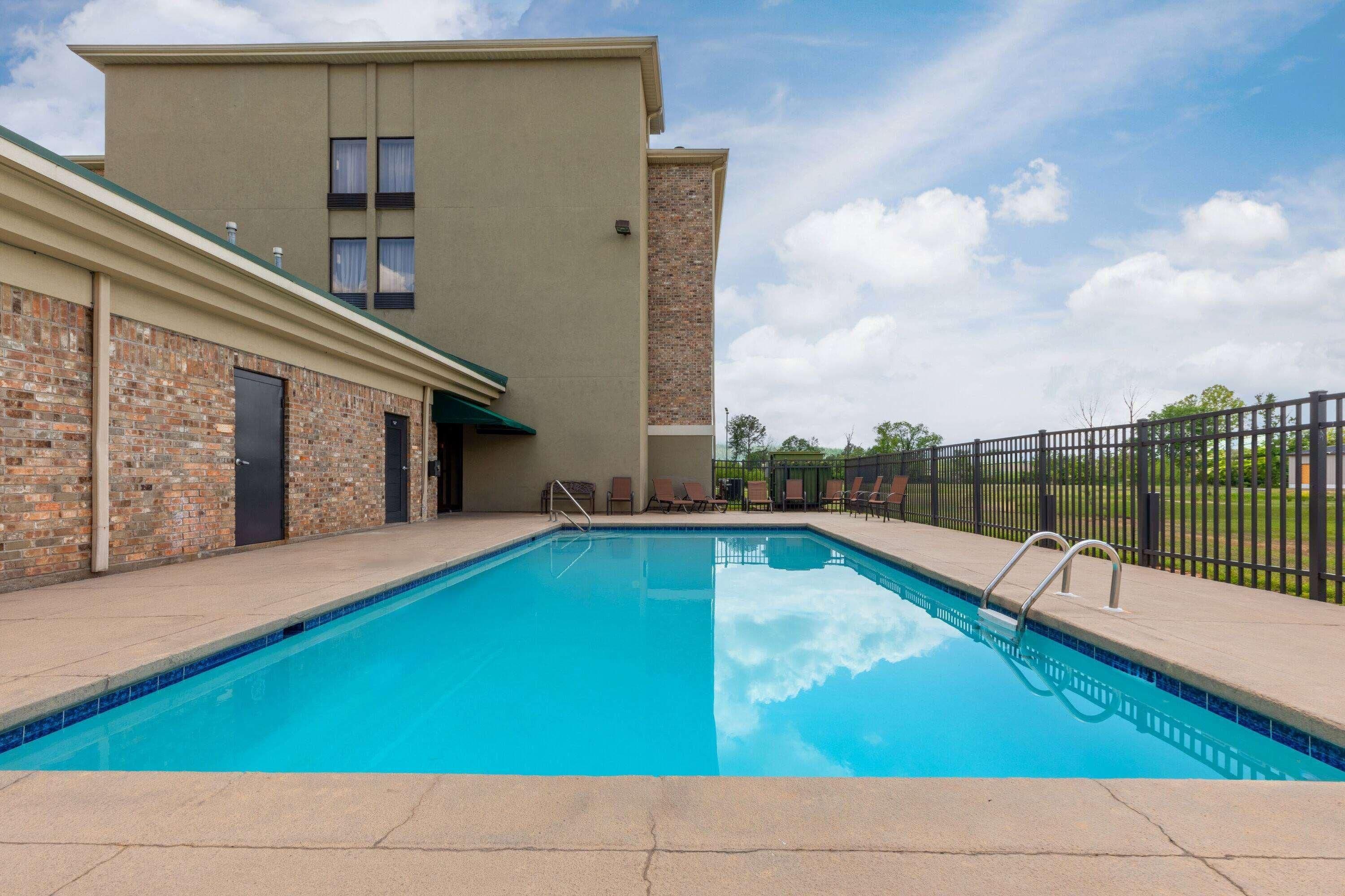 A swimming pool with a brick wall and a building in the background.
