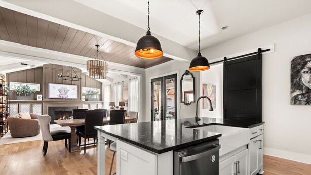 A modern kitchen with a central island, black pendant lights, and a large black-framed mirror. - The Blue Note - Luxe Outdoor Retreat & Pool - Close to Downtown (Nashville)