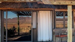 A covered outdoor seating area with a view of a desert landscape. - Mountain View Villa (Pacific Harbour)