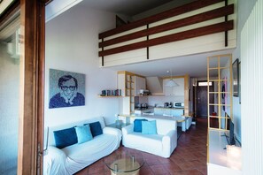 A modern living room with a sofa, a coffee table, and a kitchen in the background.