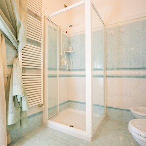 Chuveiro, toalhas de banho, sabonete, shampoo