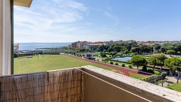Un balcone con vista su un campo sportivo, una pista di atletica e uno specchio d'acqua.