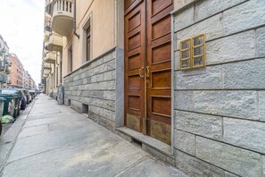 Un edificio de piedra con una puerta de madera grande y una pequeña ventana con un letrero.