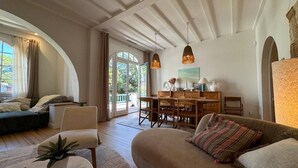 Una sala de estar amplia con un sofá grande, una mesa de comedor y una zona de estar acogedora.