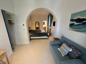 Een moderne hotelkamer met een bed, een slaapbank en een schilderij van een golf.