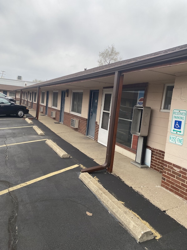 A motel with a parking lot, a reserved parking sign, and a building with a brick facade.