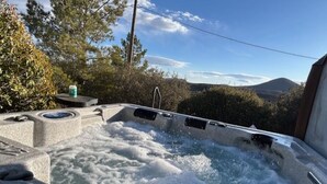 Uma banheira de hidromassagem com vista para montanhas e árvores.
