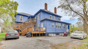 A two-story blue house with a wooden staircase leading to a balcony. - Norfolk Apartment: 1 Mi to Ocean View Beach Park! (Norfolk)