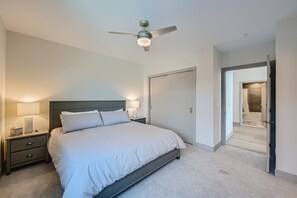 Relax in this serene bedroom with a large bed and two bedside tables, each with a lamp.