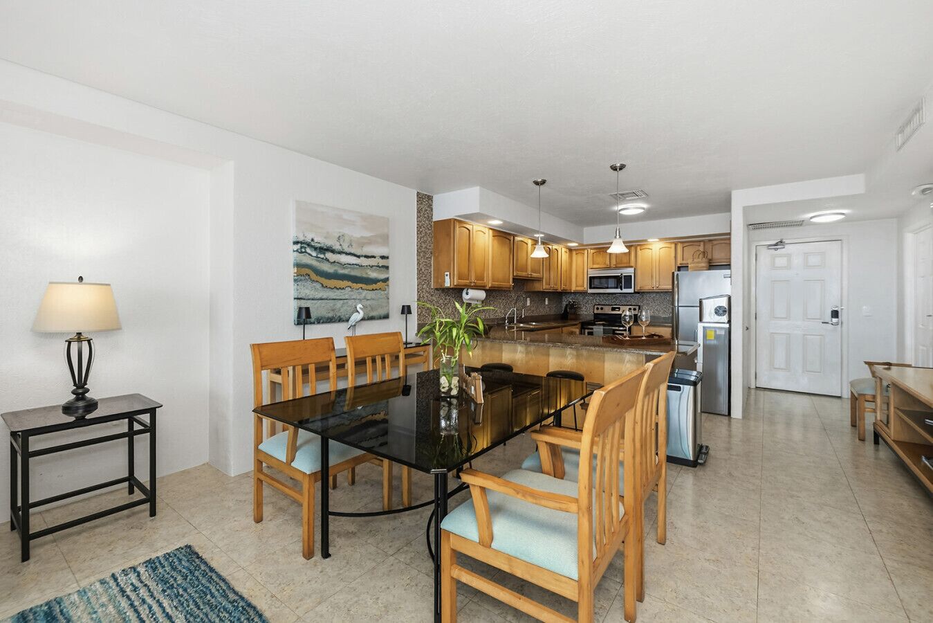 A modern kitchen with wooden cabinets, a central island, and stainless steel appliances.
